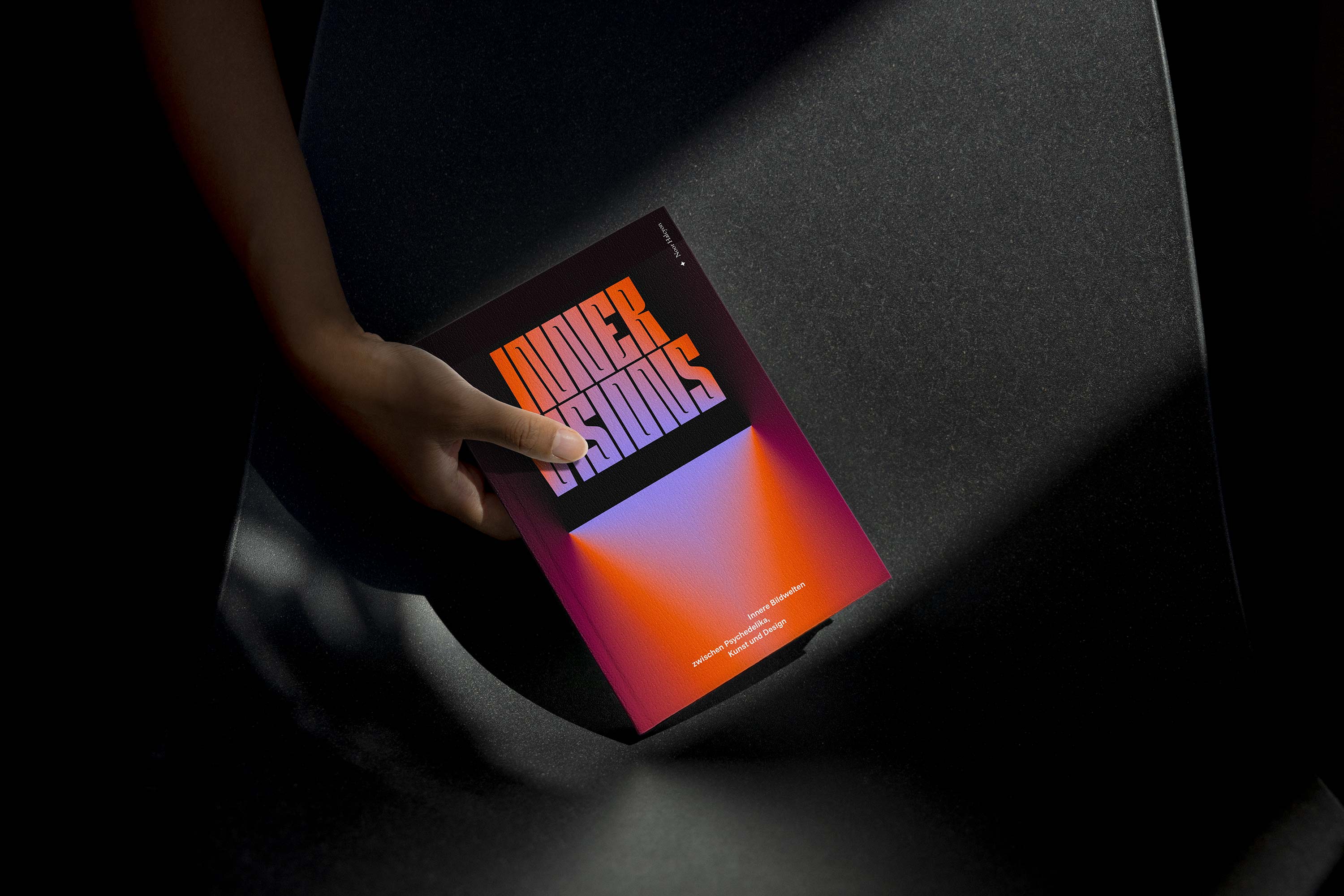 Buch-Mockup: Innere Visionen von Noor Halcyon, gehalten von einer Hand im Streiflicht